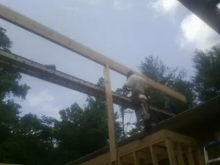 Carpenter setting a ridge beam over a new addition frame — Ice Dam Removal by Roofing Brothers in Deptford