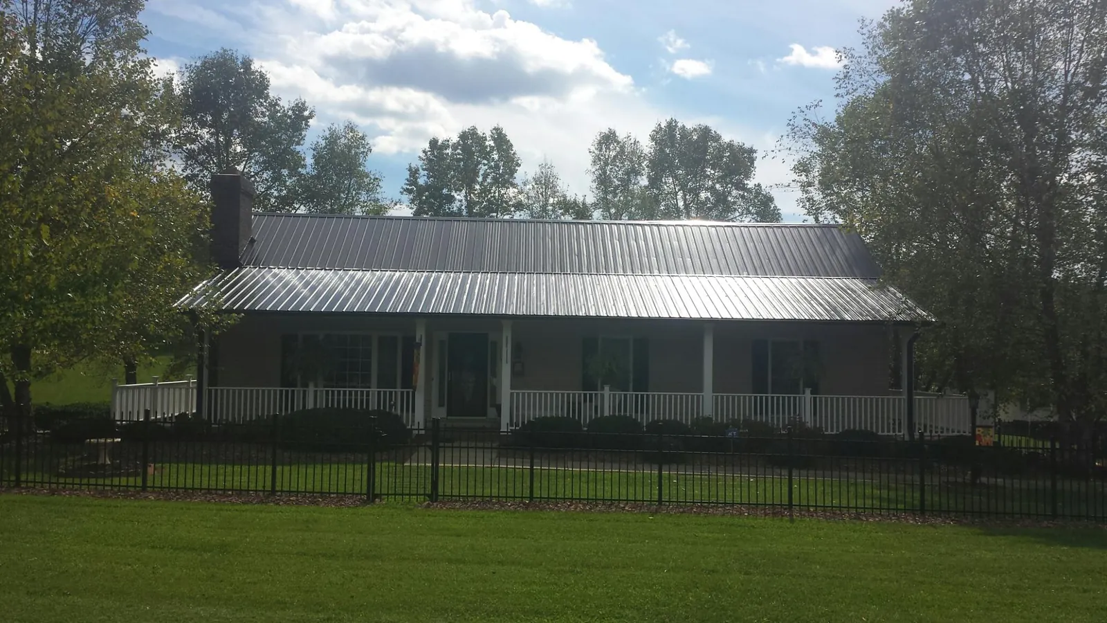 Gray metal roof on a brick ranch with a full width front porch — Gutter Guard Installation work by our crew in Deptford