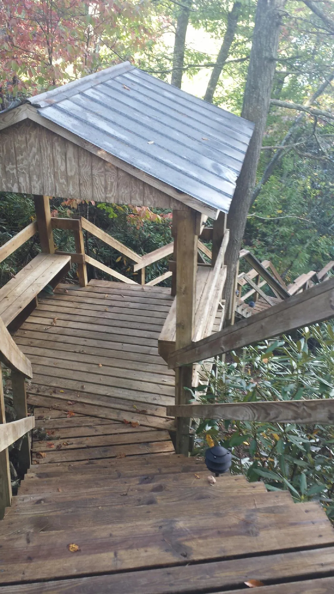 Metal roofed shelter over wooden steps on a wooded walkway — Skylight Repair & Installation work by our crew in Deptford